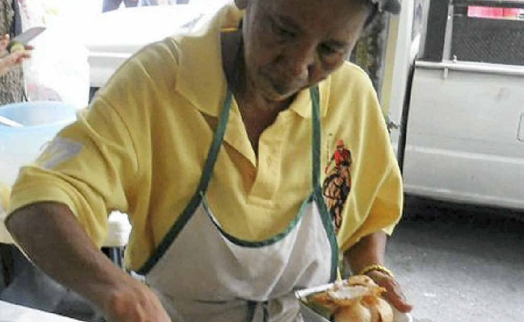 A woman makes a mountainous heap of crispy chicken on the streets of Bangkok. A woman makes a mountainous heap of crispy chicken on the streets of Bangkok.